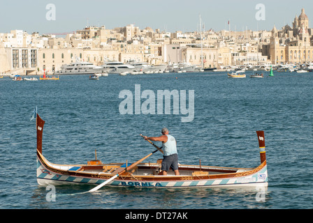 Maltese man rowing a traditional craft at a regatta on Grand Harbour, Valletta Stock Photo