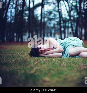 Portrait of woman sleeping on grass in park Stock Photo