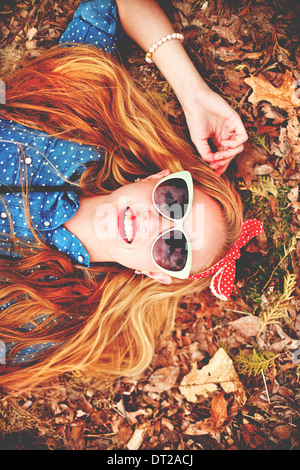 Portrait of young woman lying down on ground Stock Photo