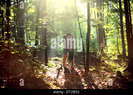 Young couple embracing in forest Stock Photo