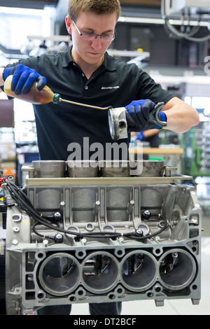 Mercedes-AMG engine production factory in Germany engineer applies lubricant oil to cylinders for pistons of 6.3 litre V8 engine Stock Photo