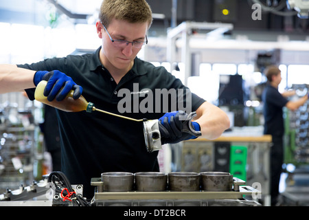 Mercedes-AMG engine production factory in Germany engineer applies lubricant oil to cylinders for pistons of 6.3 litre V8 engine Stock Photo
