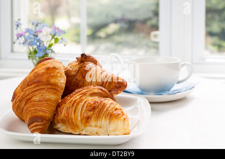 Three fresh baked croissants on plate for breakfast Stock Photo