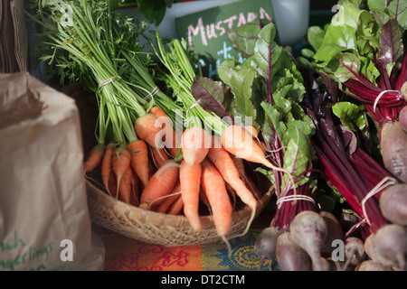 Fresh carrots and beets with tops, displayed at an outdoor farmers market on Quadra Street in Victoria, BC Stock Photo