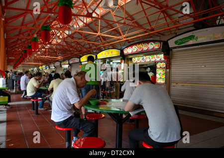 Chinese male diners eat hawker food at outdoor tables Maxwell Food Center Singapore Stock Photo