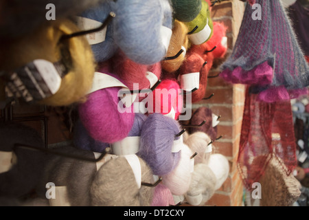 Balls of multicolored yarn hanging side by side in a shop Stock Photo