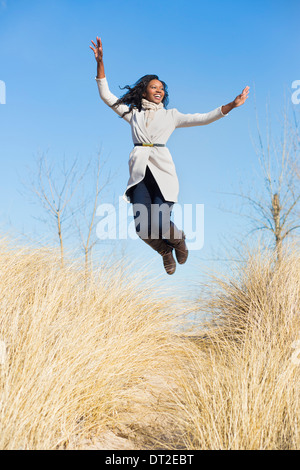 USA, Illinois, Waukegan, Happy woman jumping in grass Stock Photo