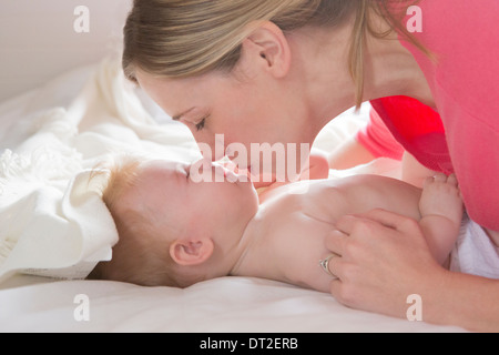 Mother kissing her baby daughter (6-11 months) Stock Photo