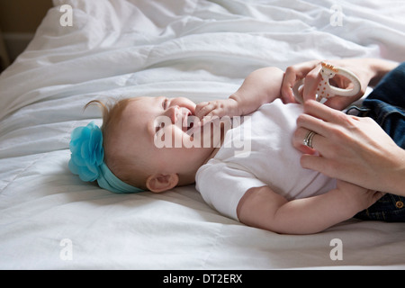 Baby girl (6-11 months) lying down on bed Stock Photo