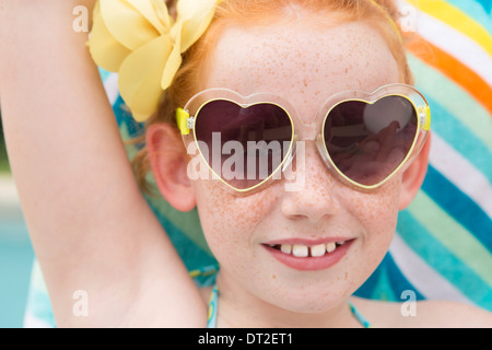Close up of girl (10-11) wearing heart shape glasses Stock Photo
