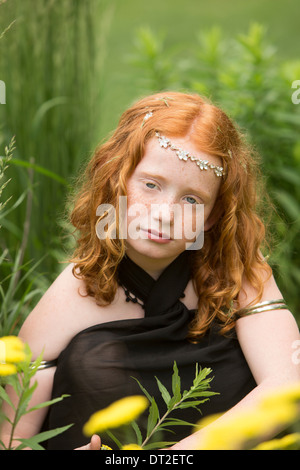 Portrait of girl (10-11) sitting in grass
