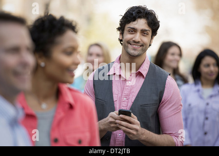 park and one young man holding a mobile phone Stock Photo