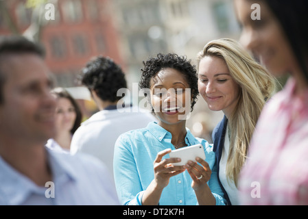 two women looking at a cell phone Stock Photo