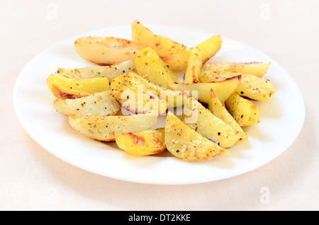 Fried potato wedges on white plate Stock Photo