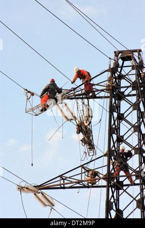 Workers at electricity pylons in Italy. Maintenance work of a high-voltage power line. Stock Photo