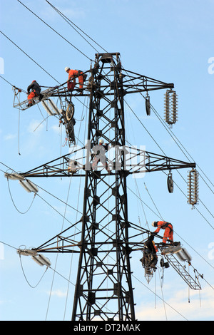 Workers at electricity pylons in Italy. Maintenance work of a high-voltage power line. Stock Photo