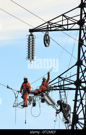 Workers at electricity pylons in Italy. Maintenance work of a high-voltage power line. Stock Photo