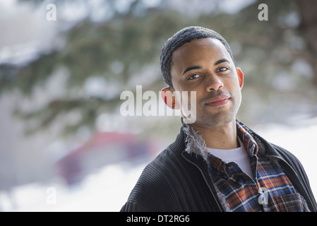 Winter scenery with snow on the ground A man wearing a checked shirt and open jacket Stock Photo