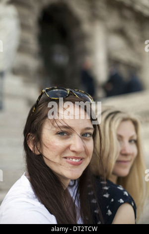 Two women in the street in the historic city of Rome A blonde haired woman and a brunette Stock Photo