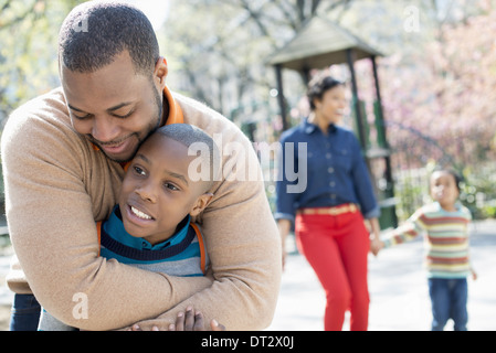 A family parents and two boys spending time together A father hugging his son Stock Photo