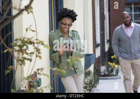 A man approaching a woman who is checking her phone Stock Photo