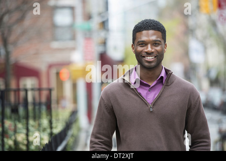 A young man wearing a purple shirt and jersey smiling Stock Photo