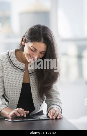 Young professionals at work A woman at a work table using a digital tablet Stock Photo