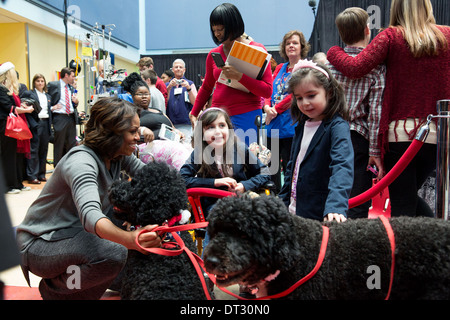 US First Lady Michelle Obama with family pets Bo and Sunny, greets children during a Christmas holiday program at the Children’s National Medical Center November 16, 2013 in Washington, DC. Stock Photo