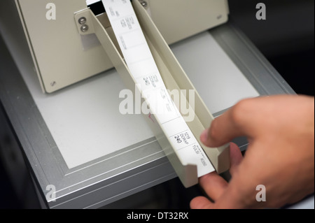 An air traffic controller in an air traffic control centre is taking flight process strips out of the printing machine Stock Photo