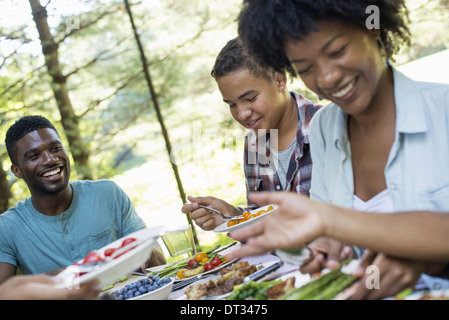 Parents and children helping themselves to fresh fruits and vegetables Stock Photo