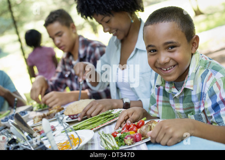 Parents and children helping themselves to fresh fruits and vegetables Stock Photo