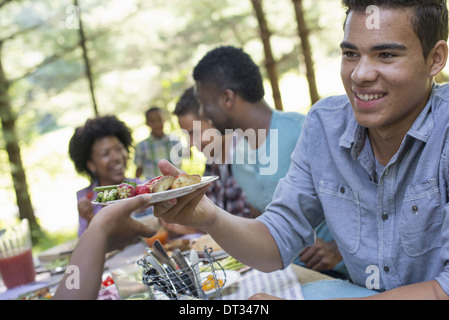 Parents and children helping themselves to fresh fruits and vegetables Stock Photo