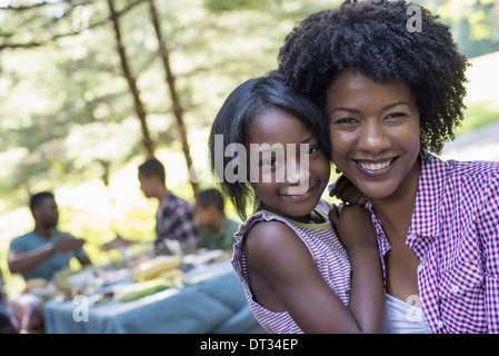 A young girl and adults seated at the table Stock Photo