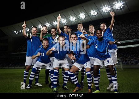 Soccer team cheering on field Stock Photo