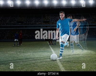 Soccer player approaching ball on field Stock Photo