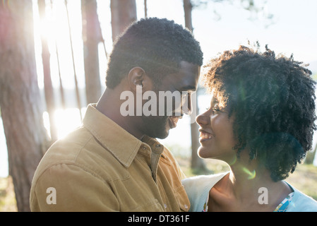 A happy couple in a shady spot in woodland in summer Hugging and holding each other Stock Photo