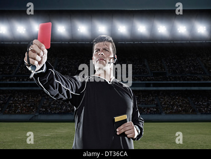 Premium Photo  Composition of male referee holding red card and player at  football stadium