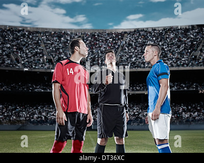 Referee tossing coin in soccer game Stock Photo