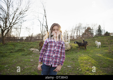 A child, a young girl in the goat paddock enclosure at an animal sanctuary. Stock Photo