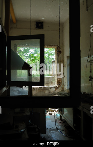 Window frames with broken glass in abandoned factory. Unrolled tape on the floor. Stock Photo