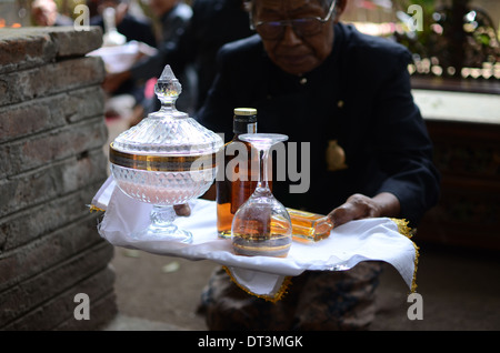 A village elder leading the ritual offerings of liquor at the tomb of Prabu Anom in Doko village Stock Photo