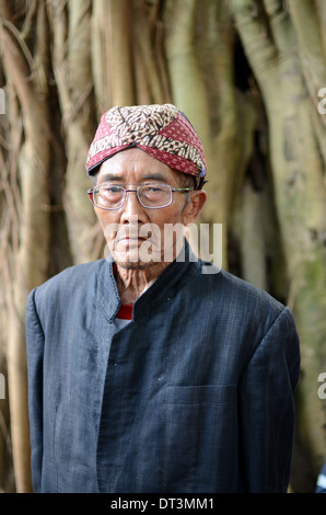 A village elder leading the ritual offerings of liquor at the tomb of Prabu Anom in Doko village Stock Photo