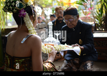 A village elder leading the ritual offerings of liquor at the tomb of Prabu Anom in Doko village Stock Photo