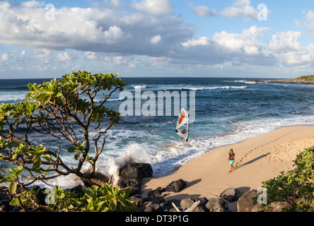 Windsurfer, surfer and stroller at Hookipa Beach on Maui at sunset Stock Photo