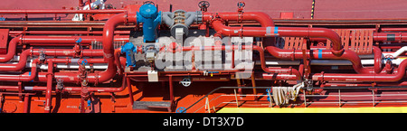 Red-painted pipework detail aboard a bunkering vessel in Gibraltar harbour. Stock Photo