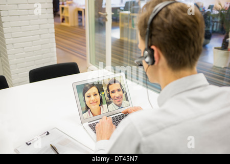 Male calling computer desk video phone Stock Photo