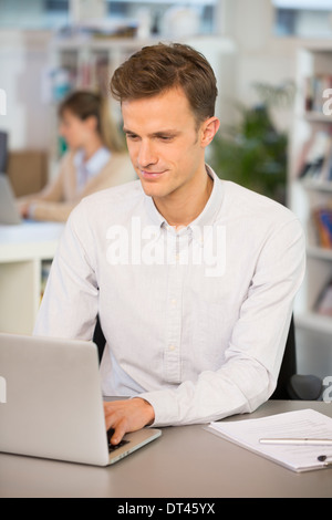 Man Cheerful desk laptop young colleagues Stock Photo