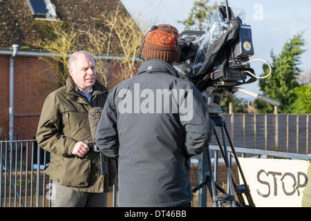 Burrowbridge, Somerset, UK. 8th February 2014. Conservative MP Mr Ian Liddell-Grainger being interviewed by BBC News on 8th February 2014 standing on the bridge over the River Parrett on the A361 at Burrowbridge, Somerset. Due to heavy rainfall, the rivers Parrett and Tone have burst their banks flooding nearby farmland and leaving houses underwater. Following visits by Lord Chris Smith and David Cameron yesterday, a severe flood alert remains and some occupants have been told to evacuate. The Somerset Levels have experienced the worst flooding in living history. Credit:  Nick Cable/Alamy Live