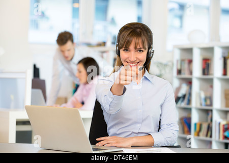 Happy business woman desk smiling point finger computer Stock Photo