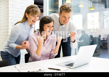 Woman man computer desk smiling celebrating triumph Stock Photo